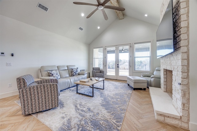 living area featuring high vaulted ceiling, french doors, visible vents, and a stone fireplace