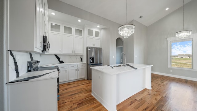 kitchen with appliances with stainless steel finishes, white cabinets, a notable chandelier, and a sink