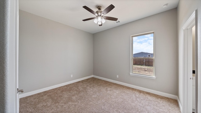 carpeted spare room with ceiling fan, visible vents, and baseboards