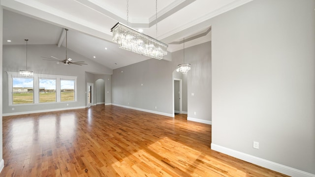 unfurnished living room with arched walkways, high vaulted ceiling, baseboards, beam ceiling, and light wood finished floors