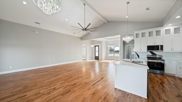 kitchen with stainless steel appliances, a sink, visible vents, open floor plan, and light wood-type flooring