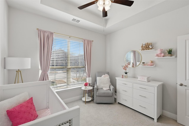 bedroom with light carpet, a raised ceiling, visible vents, and baseboards