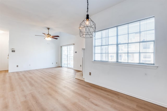 unfurnished room featuring ceiling fan, light wood-style flooring, and baseboards