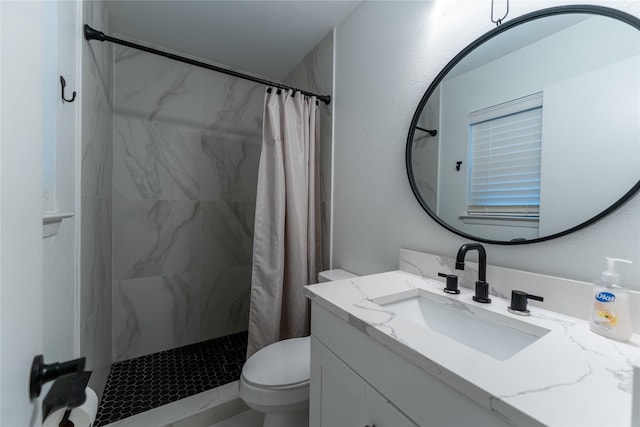 bathroom with a stall shower, vanity, and toilet