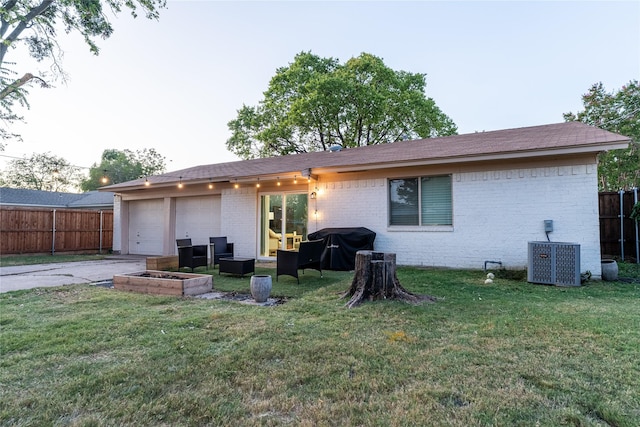 rear view of house with a yard, fence, central AC unit, and brick siding