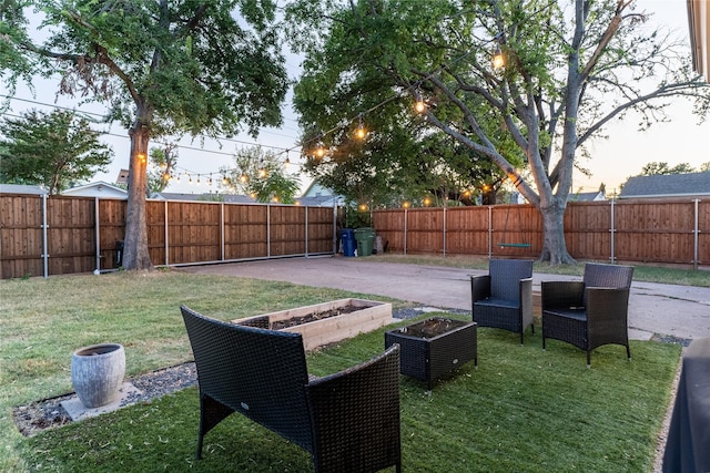 view of yard with a patio, a fenced backyard, and a garden