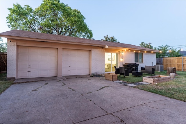 ranch-style house with a garage, fence, cooling unit, and brick siding