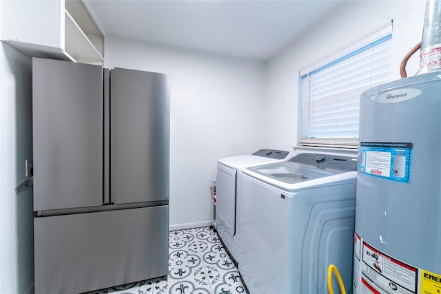 clothes washing area with light tile patterned floors, water heater, cabinet space, separate washer and dryer, and baseboards