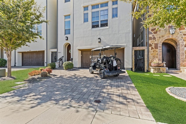 exterior space with a garage and decorative driveway