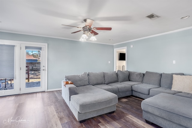 living room with ceiling fan, wood finished floors, visible vents, baseboards, and crown molding