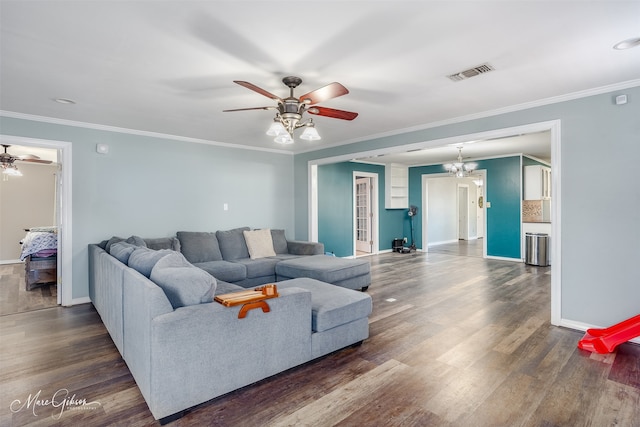 living area featuring ornamental molding, visible vents, and wood finished floors