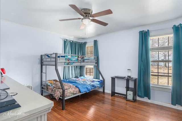 bedroom featuring crown molding, multiple windows, and wood finished floors