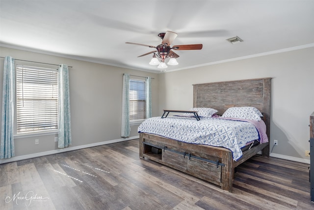 bedroom featuring visible vents, crown molding, baseboards, and wood finished floors