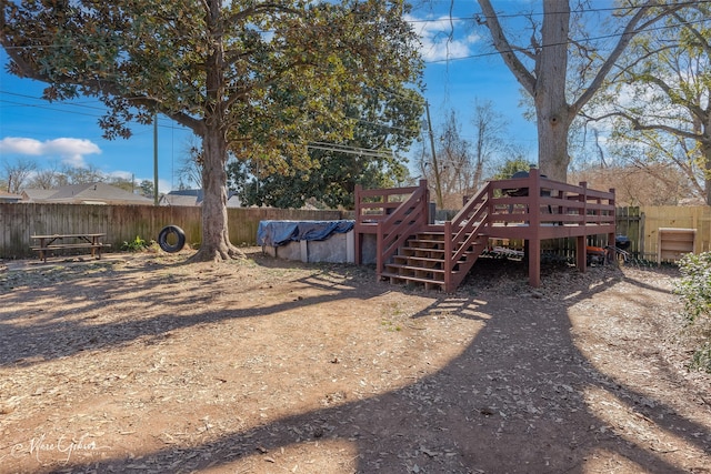 view of yard featuring a fenced in pool, a fenced backyard, and a wooden deck