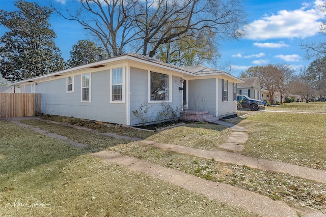 view of front of home with a front yard and fence