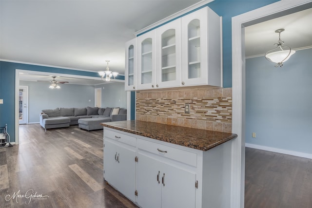 kitchen featuring tasteful backsplash, ornamental molding, white cabinets, and dark wood-type flooring