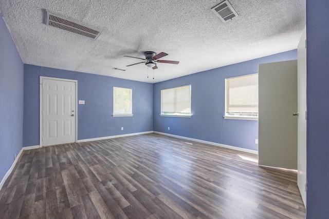 empty room featuring wood finished floors, visible vents, and a ceiling fan