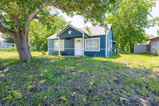 bungalow with fence and a front lawn