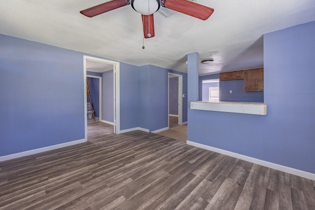 unfurnished living room with ceiling fan, wood finished floors, and baseboards