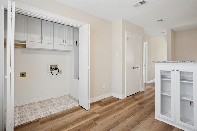 washroom featuring baseboards, visible vents, wood finished floors, washer hookup, and electric dryer hookup