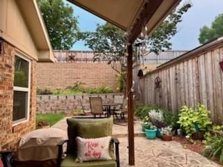 view of patio / terrace with outdoor dining space, grilling area, and a fenced backyard