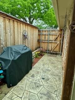 view of patio / terrace with a grill, a gate, and fence