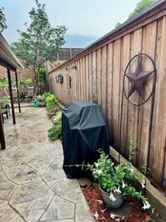 view of patio with a grill and fence