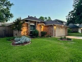 view of front of home featuring an attached garage, driveway, a front lawn, and fence