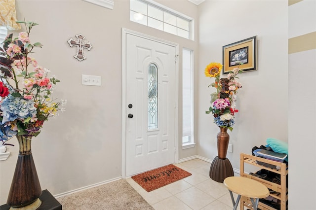 foyer entrance featuring light tile patterned flooring and baseboards