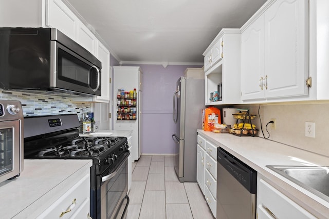 kitchen featuring white cabinetry, light countertops, appliances with stainless steel finishes, backsplash, and crown molding