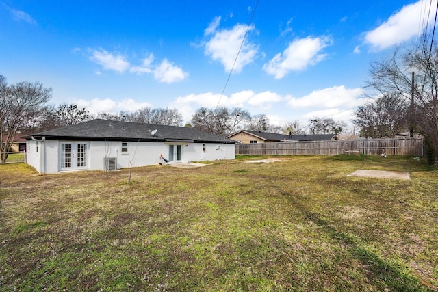 view of yard featuring french doors, central AC unit, and fence