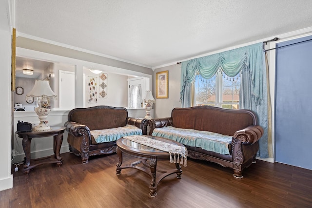 living room with a textured ceiling, ornamental molding, and wood finished floors