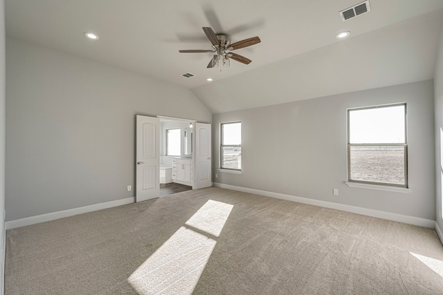 unfurnished bedroom with carpet, visible vents, vaulted ceiling, and baseboards