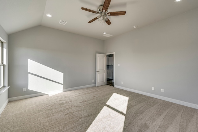 carpeted empty room featuring lofted ceiling, recessed lighting, a ceiling fan, visible vents, and baseboards