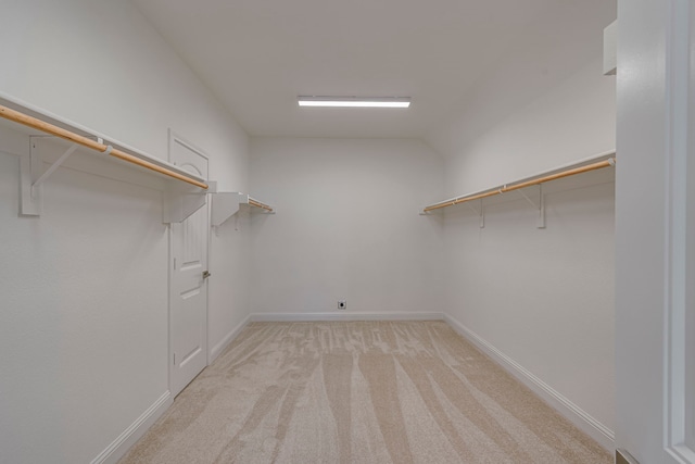 spacious closet featuring light carpet and lofted ceiling