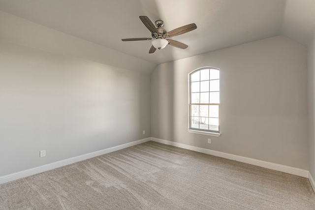 unfurnished room with lofted ceiling, ceiling fan, carpet flooring, and baseboards