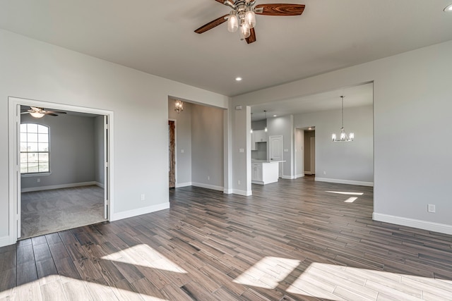 unfurnished living room with dark wood finished floors, baseboards, and ceiling fan with notable chandelier