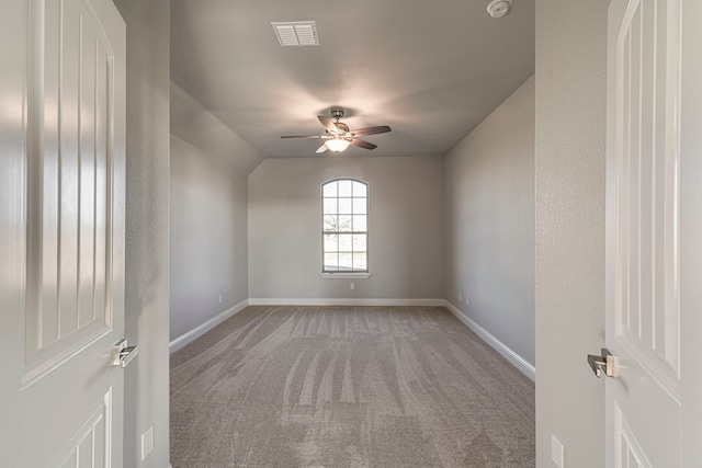 empty room featuring a ceiling fan, carpet flooring, visible vents, and baseboards