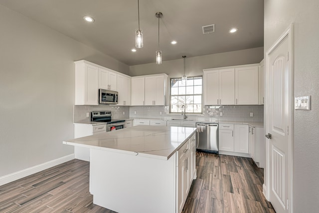 kitchen featuring appliances with stainless steel finishes, visible vents, a sink, and tasteful backsplash