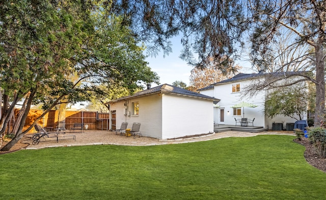 back of property featuring brick siding, fence, a deck, and a yard