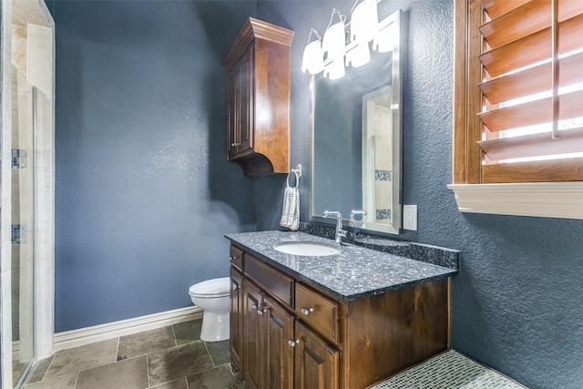 bathroom with toilet, baseboards, a shower, and vanity