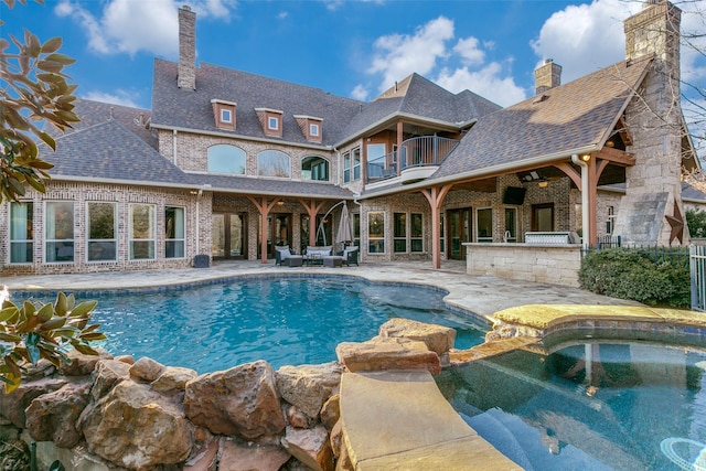 view of pool featuring a pool with connected hot tub and a patio