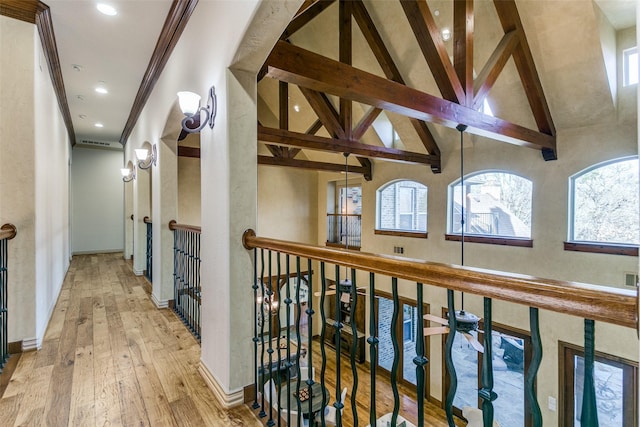 corridor with high vaulted ceiling, baseboards, ornamental molding, hardwood / wood-style floors, and beamed ceiling