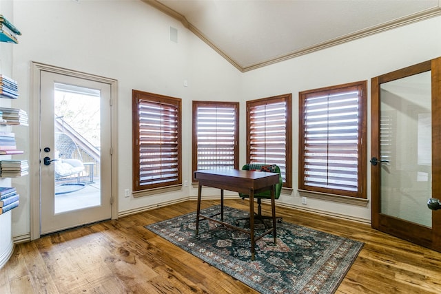 home office with crown molding, plenty of natural light, high vaulted ceiling, and wood finished floors