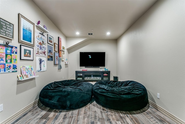 living area with baseboards, visible vents, wood finished floors, and recessed lighting