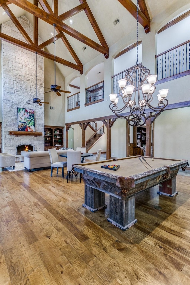 recreation room with visible vents, billiards, a stone fireplace, and hardwood / wood-style flooring