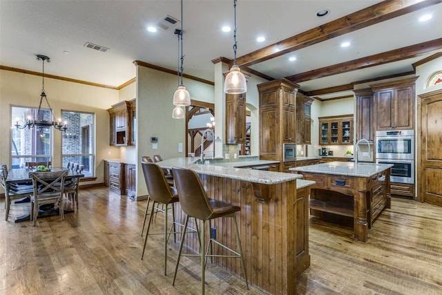 kitchen featuring light stone countertops, visible vents, and wood finished floors