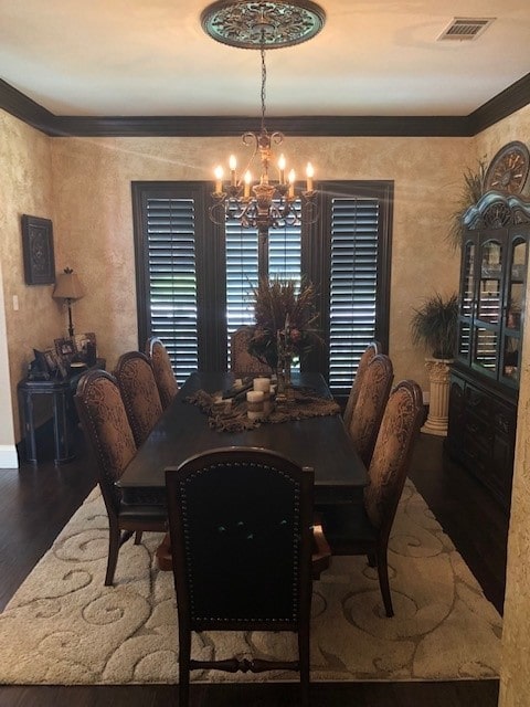 dining room featuring a chandelier, visible vents, baseboards, and wood finished floors