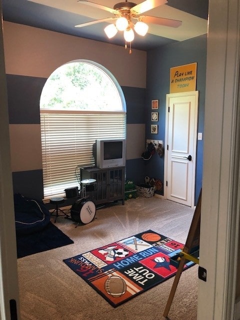 interior space with carpet flooring and a ceiling fan