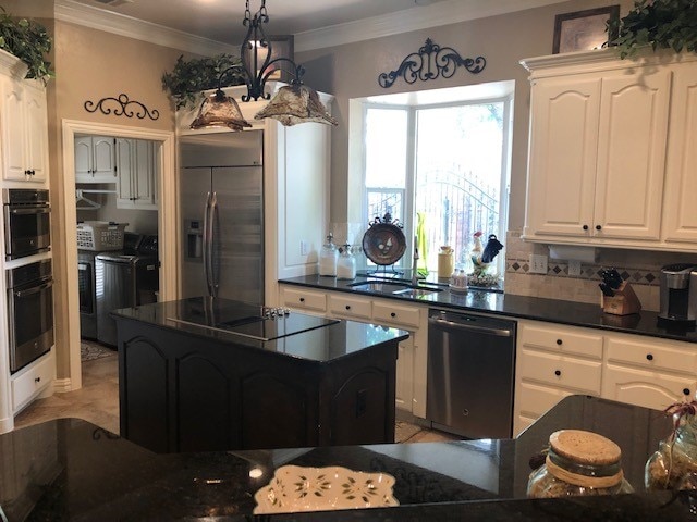 kitchen featuring crown molding, stainless steel fridge, dishwasher, and white cabinetry